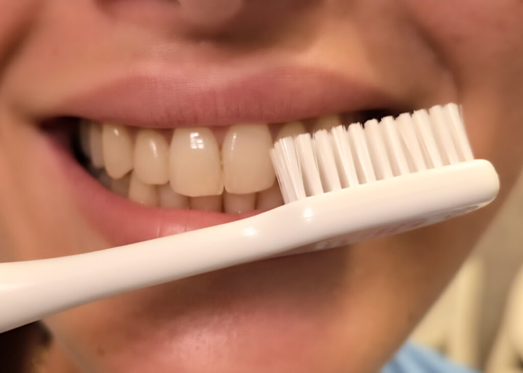 Dopo Aver Mangiato, I Denti Vanno Spazzolati Subito o Bisogna Aspettare? La corretta igiene orale è fondamentale per mantenere i denti sani e prevenire problemi come la carie, la gengivite e la sensibilità dentale. Tuttavia, uno dei dubbi più comuni riguarda il momento giusto per spazzolare i denti dopo i pasti. Molti si chiedono se sia meglio spazzolare subito dopo aver mangiato, oppure se, al contrario, sia più consigliato aspettare qualche minuto. In effetti, questa domanda ha suscitato molte controversie negli ultimi anni, in particolare a causa degli effetti del pH della saliva sui denti subito dopo i pasti. Nel corso di questo articolo, esploreremo le ragioni scientifiche dietro il dibattito e offriremo una guida su quando è più opportuno spazzolare i denti per mantenerli in salute. Il Ruolo del pH della Saliva dopo i Pasti Quando mangiamo, il pH della nostra saliva subisce un abbassamento temporaneo, diventando più acido. Questo accade a causa della presenza di cibi e bevande acide, che possono alterare l’ambiente orale. Un pH acido in bocca è una condizione favorevole alla demineralizzazione dei denti, cioè il processo attraverso il quale i minerali vengono rimossi dallo smalto dei denti, lasciandoli più vulnerabili all'erosione. Il pH della saliva di norma è neutro o lievemente alcalino, ma dopo aver mangiato, soprattutto se si consumano alimenti acidi come agrumi, succhi di frutta, bevande gassate o cibi zuccherati, può scendere fino a livelli che favoriscono la perdita di minerali dallo smalto. Questo processo è temporaneo e, in condizioni normali, il pH della saliva ritorna gradualmente a livelli più neutrali, un fenomeno che può richiedere dai 20 ai 30 minuti. Il Dibattito sul Momento Giusto per Spazzolare i Denti Proprio a causa di questa temporanea acidità della saliva, uno dei timori principali legati al spazzolamento subito dopo il pasto è che si rischia di rimuovere involontariamente i cristalli di smalto e dentina che potrebbero essere stati indeboliti dall’acidità. Infatti, quando il pH della bocca è acido, lo smalto dei denti è più morbido e può essere danneggiato da una spazzolatura immediata e vigorosa, che potrebbe accelerare il processo di erosione dentale. Per questo motivo, negli ultimi anni, alcuni esperti di salute dentale hanno consigliato di aspettare almeno 20-30 minuti dopo aver mangiato prima di spazzolare i denti. In questo lasso di tempo, il pH della saliva tende a stabilizzarsi e a tornare a livelli normali, riducendo così il rischio di danneggiare lo smalto. Durante questo periodo di attesa, la saliva svolge un ruolo protettivo, favorendo la remineralizzazione dello smalto e permettendo ai denti di recuperare senza il rischio di danneggiarli con il spazzolamento immediato. È Opportuno Spazzolare i Denti Subito Dopo il Pasto? Nonostante le raccomandazioni di aspettare qualche minuto, ci sono casi in cui spazzolare i denti subito dopo aver mangiato è ancora una scelta valida. Se, per esempio, la tua pausa pranzo è limitata nel tempo e non hai la possibilità di aspettare mezz’ora prima di tornare al lavoro, è importante spazzolare i denti, anche se immediatamente dopo il pasto. In questi casi, è comunque possibile ridurre i rischi seguendo alcune precauzioni: 1. Non Spazzolare con Troppa Forza: Evita di spazzolare i denti in modo troppo energico. Un movimento delicato e con una spazzola a setole morbide è sempre preferibile per evitare danni allo smalto. 2. Usa un Dentifricio Delicato: Opta per un dentifricio che non sia troppo abrasivo, in modo da ridurre il rischio di danneggiare i denti, soprattutto quando sono più vulnerabili a causa del pH acido. 3. Bevi Acqua Dopo il Pasto: Se non puoi aspettare, bere un bicchiere d’acqua dopo il pasto aiuta a neutralizzare l’acidità della saliva, favorendo un ambiente orale meno acido e più sicuro per lo spazzolamento. 4. Risciacqua la Bocca: Un altro consiglio utile è risciacquare la bocca con acqua o con un collutorio prima di spazzolare. Questo aiuta a rimuovere le particelle di cibo in eccesso e a ridurre temporaneamente l'acidità. Altri Consigli per Mantenere i Denti Sani Dopo i Pasti Indipendentemente dal momento in cui scegli di spazzolare i denti, ci sono altre buone abitudini che possono contribuire alla salute orale generale: 1. Bevi Acqua Regolarmente: L’acqua è fondamentale per mantenere una buona salivazione, che a sua volta aiuta a neutralizzare l’acidità in bocca e a rimuovere i residui di cibo. 2. Visite Regolari dal Dentista: Anche se segui tutte le raccomandazioni per l’igiene orale, è sempre una buona idea sottoporsi a controlli periodici dal dentista per rilevare tempestivamente eventuali problemi dentali e trattarli prima che diventino gravi. Conclusione In generale, la regola migliore è quella di aspettare circa 20-30 minuti dopo i pasti prima di spazzolare i denti. Questo permette al pH della saliva di stabilizzarsi e riduce il rischio di danneggiare lo smalto dentale. Tuttavia, se per motivi di tempo hai bisogno di spazzolare subito, è fondamentale farlo con delicatezza, utilizzando una spazzola morbida e un dentifricio delicato, e magari risciacquando la bocca con acqua per ridurre l'acidità prima dello spazzolamento. Ricorda che, al di là del momento preciso in cui spazzolare, mantenere una buona igiene orale quotidiana è essenziale per la salute dei tuoi denti nel lungo termine.